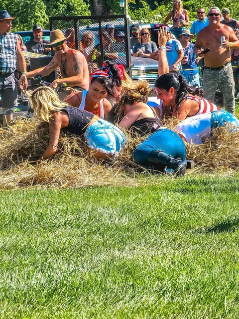 Festival-goers competing in a field event in front of a cheering crowd